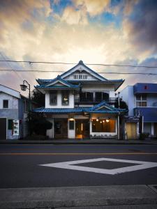a white building with an asian roof on a street at Wonderlust Inn in Kamakura