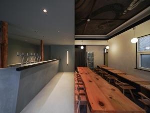 a long wooden table in a restaurant with benches at Wonderlust Inn in Kamakura