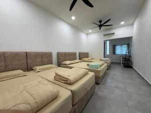 a room with four beds and a ceiling fan at Ipoh TZY's Homestay in Ipoh