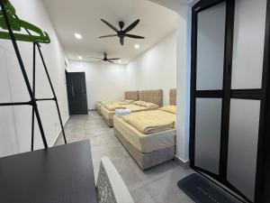 a bedroom with two beds and a ceiling fan at Ipoh TZY's Homestay in Ipoh