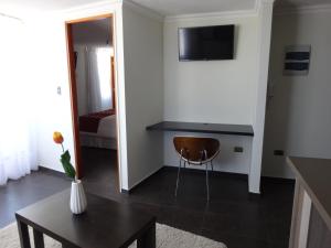 een woonkamer met een bureau en een tafel bij Tempora Apart Hotel in Antofagasta