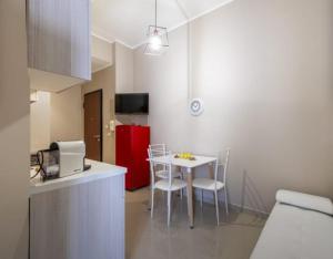 a kitchen with a table and chairs and a red refrigerator at Aura Deluxe Apartments in Syracuse