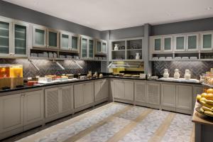 a large kitchen with white cabinets and fruits on the counter at Hyatt Place Columbus/Dublin in Dublin