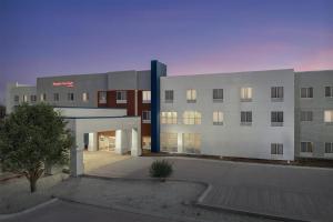 a large white building with a parking lot in front of it at Hampton Inn & Suites Roswell in Roswell