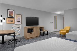 a hotel room with a tv and a table and chairs at Hampton Inn & Suites Roswell in Roswell