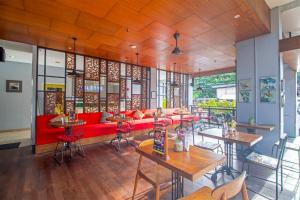 a restaurant with a red couch and tables and chairs at Palette Legian Beach in Legian