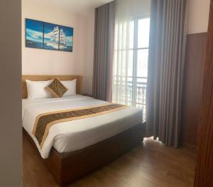 a bedroom with a bed and a large window at Hotel Kim Thái in Phú Quốc +3 photos