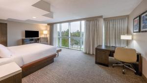 a hotel room with a bed and a desk with a computer at Embassy Suites by Hilton Seattle Bellevue in Bellevue