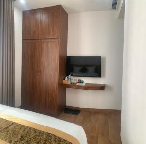 a room with a tv and a cabinet and a television at Hotel Kim Thái in Phú Quốc