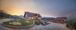 a house with cars parked in a parking lot at Hill Seasons Resorts and SPA in Tindummal
