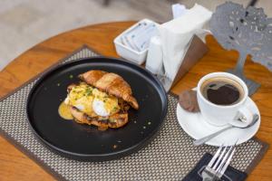 a black plate with a sandwich and a cup of coffee at Palette Legian Beach in Legian
