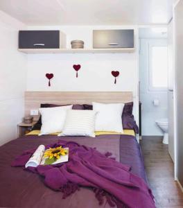 1 dormitorio con 1 cama grande con manta morada en Victoria Mobilhome Camping Park Soline, en Biograd na Moru