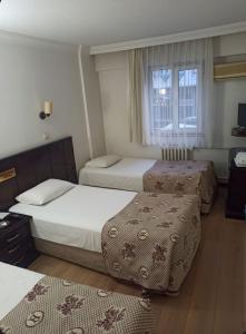 a hotel room with three beds and a window at SPOR HOTEL in Ankara +29 photos