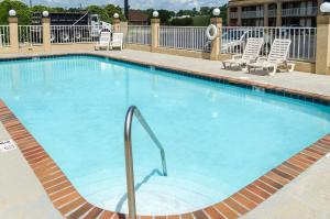 a swimming pool at a hotel with lounge chairs at Rodeway Inn Vicksburg in Vicksburg