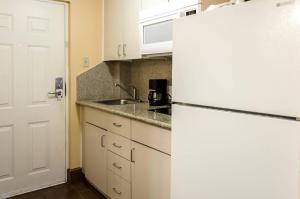 a kitchen with a white refrigerator and a sink at Rodeway Inn Vicksburg in Vicksburg