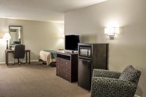 a hotel room with a desk with a chair and a television at Comfort Inn Sandusky in Sandusky