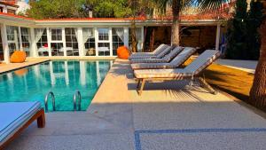 a group of lounge chairs next to a swimming pool at Jardin d'Azur Alaçatı in Alaçatı