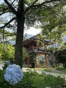 a log cabin with a balcony in a garden at ANOR - Farmstay - Double bed in Ha Tia