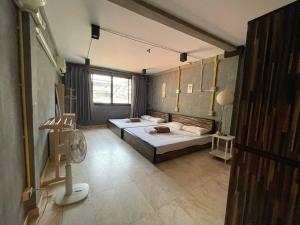 a room with two beds and a fan in it at Brio Cafe and Hostel in Godown