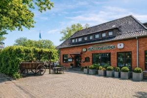 a brick building with a horse drawn carriage outside at Hotel Rüstersieler Hof in Wilhelmshaven