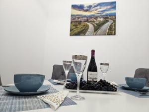 a table with wine glasses and grapes on it at Apartmani TEŠNJAR VALJEVO in Valjevo