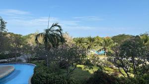 a view of a resort with a swimming pool and trees at 1 BR Loft Condo in Cha-Am in Cha Am