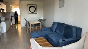 a living room with a blue couch and a table at 1 BR Loft Condo in Cha-Am in Cha Am