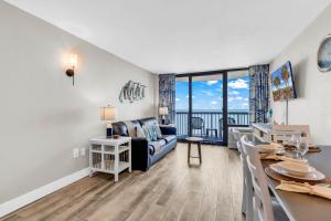a living room and dining room with a couch and a table at Compass Cove 1466 in Myrtle Beach