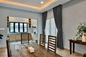 a living room with a kitchen and a table and chairs at Villa Alam Klang managed by Bella Vista Hotels & Resorts in Klang +2 photos