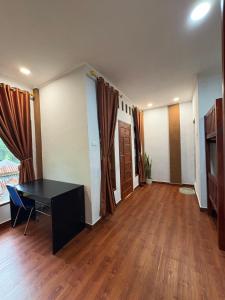 an empty room with a desk and wooden floors at Asim Paris Guesthouse & jungle trekking in Bukit Lawang