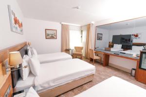 a hotel room with two beds and a desk at ARMİS HOTEL in İzmir