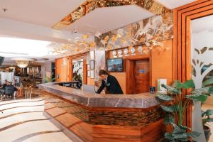 a man standing behind a bar in a restaurant at ARMİS HOTEL in İzmir