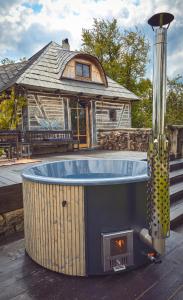 a hot tub on a deck in front of a house at Nooks by AdyBeca - Balnaca Traditional Nook in Bălnaca