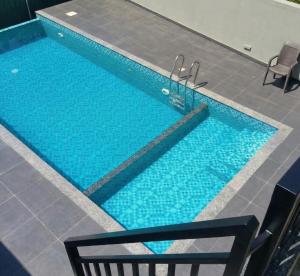a large blue swimming pool with two chairs in front of it at Hill View Vythiri Holiday Home in Vythiri