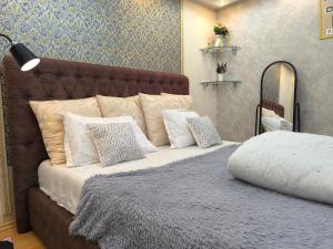 a bedroom with a bed with pillows on it at Апартаменты на Бараева in Astana