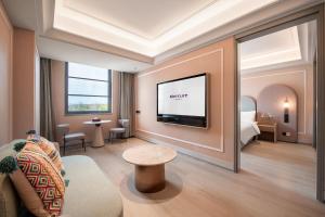 a living room with a tv and a couch at Mercure KunMing Airport in Kunming