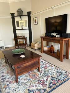 a living room with a coffee table and a flat screen tv at Lurline Villas in Katoomba
