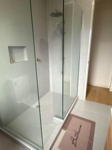 a glass shower stall with a sign on the floor at Modern Private 2BR Unit in Takapuna in Auckland