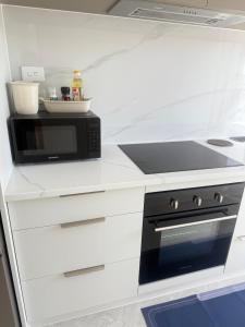 a kitchen with a stove and a microwave at Modern Private 2BR Unit in Takapuna in Auckland +19 photos