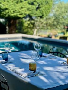 a table with wine glasses and napkins next to a pool at Demeure Bouquet in Ambierle