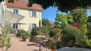 a garden with tables and chairs in front of a building at Demeure Bouquet in Ambierle