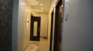 a hallway with a mirror and a sink in a room at Tokyo Inn in Howrah
