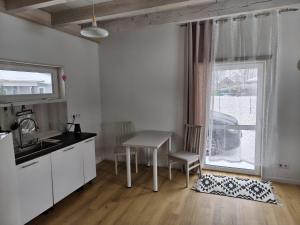 a kitchen with a table and a sink and a window at Brīvdienu māja in Jelgava