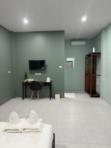 a room with a table and a desk with hats on it at Third Space House in Ban Chak Phak Kut