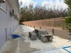 a pair of benches on a sidewalk next to a building at Third Space House in Ban Chak Phak Kut