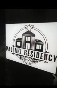 a sign for a palak university with a building at Pallaki Residency in Hubli