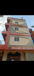 a tall building with a sign on the side of it at Pallaki Residency in Hubli