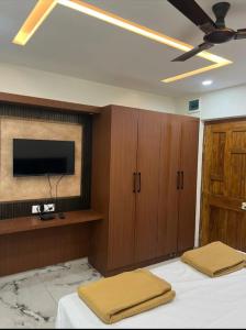 a bedroom with a bed and a flat screen tv at Pallaki Residency in Hubli