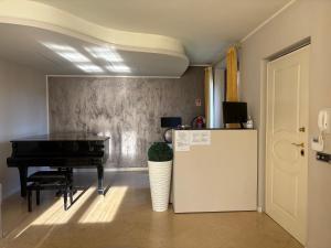 a room with a piano and a refrigerator at AirSisters Home in Ferno