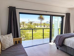 a bedroom with a bed and a large sliding glass door at Grace Eleven in Stompneusbaai